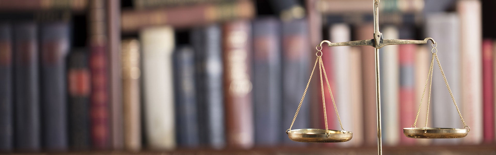 Justice scales with books in background